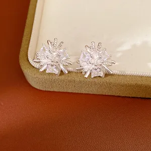 Gros plan détaillé de boucles d'oreilles fleurs en zircone cubique sur une boîte à bijoux.