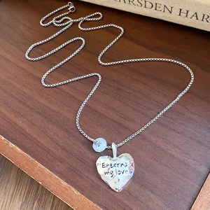 Vista dettagliata del ciondolo a cuore in argento con incisione Eternal my love e perla