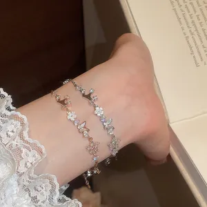 Close-up detail of elegant zircon and mother-of-pearl bracelets with butterfly charms