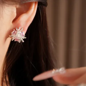 Gros plan d'une boucle d'oreille fleur en argent avec des pierres de zircon rose