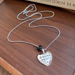 Vista dettagliata della collana con ciondolo a cuore argento e una perla nera decorativa