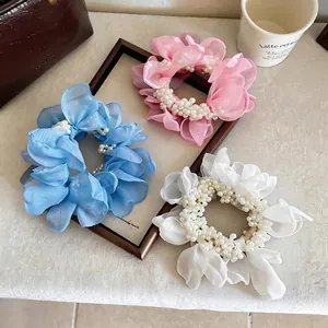 Elegant chiffon flower scrunchies with pearls in blue, pink, and white.