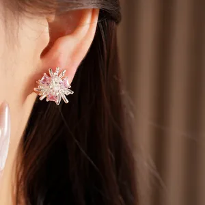 Gros plan de boucles d'oreilles fleurs avec zircon rose portées par un mannequin asiatique
