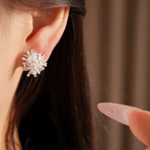 Gros plan détaillé de boucles d'oreilles fleur en argent avec zircones cubiques carrés