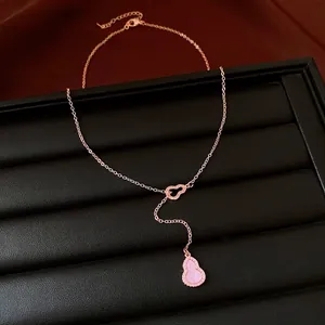 Nahaufnahme einer vergoldeten Kürbis-Halskette mit rosa Inlay und Zirkonia