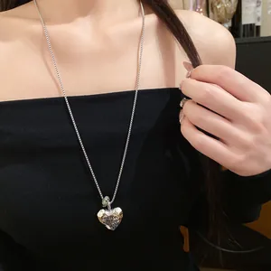 Dettaglio ravvicinato di collana a cuore in argento stropicciato con incisione e pietra