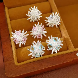 Gros plan sur des boucles d'oreilles fleurs en zircone dans une boîte à bijoux en bois