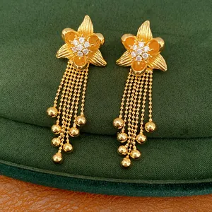 Detailed view of 18k gold plated flower earrings with sparkling zirconia and bead tassels.