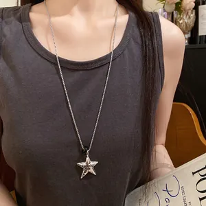 Dettaglio di un ciondolo a stella in argento plissettato con la scritta Promise me