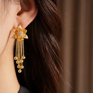 Close-up view of elegant 18k gold plated zircon flower tassel earrings on ear.