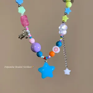 Close-up detail of colorful dopamine-style beaded necklace with star and flower charms