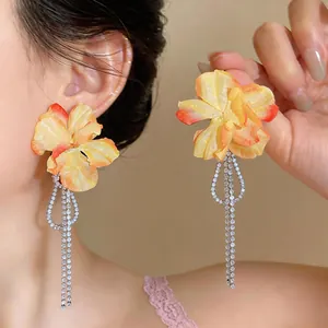 Exquisite close-up of yellow fabric flower earrings featuring sparkling zircon tassels.