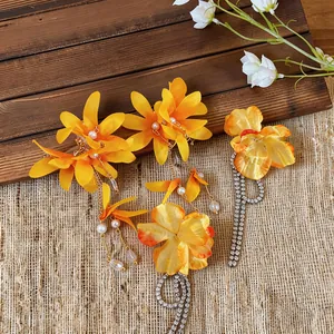 Detail showing yellow fabric flower earrings with long pearl and rhinestone tassels