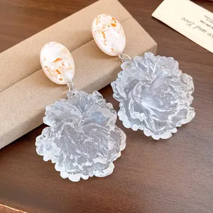 Detailed close-up of translucent resin flower earrings with intricate textured petals