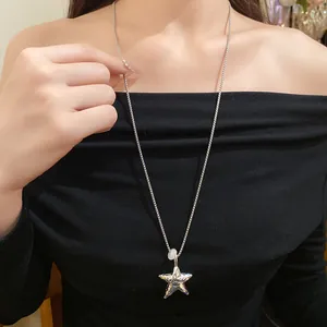 Primo piano di una collana con ciondolo a stella d'argento incisa 'Promise me'