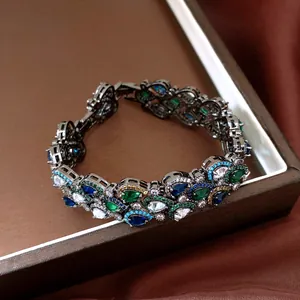 Gros plan d'un bracelet de style vintage orné d'émeraudes et de saphirs éclatants