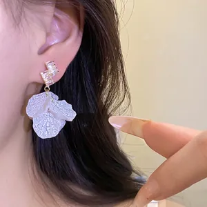 Elegant silver needle zircon earrings with white petal dangle for summer vacations