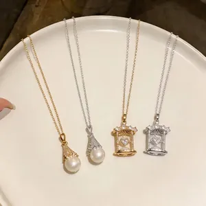 Elegant zircon fan-shaped pearl and heart hourglass necklaces displayed on a white tray