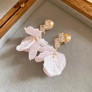 Elegant zircon flower earrings in a velvet jewelry box for a romantic vacation look.