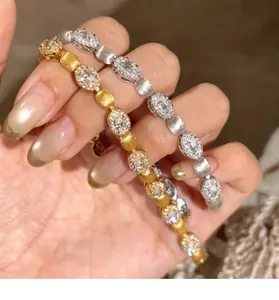 Gros plan de bracelets en or et argent avec des maillons en zircon ovale et fini brossé