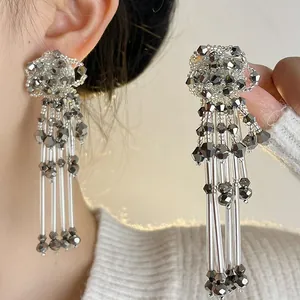 Elegant silver flower stud earrings with long beaded tassels in a luxury niche design.