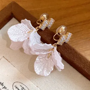 Close-up detail of elegant white petal tassel earrings with sparkling zircon stones