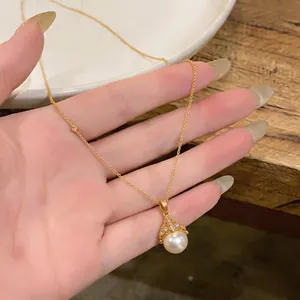 Close-up of elegant gold necklace with zircon-encrusted fan-shaped pearl pendant