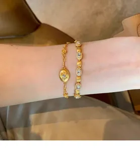 Gros plan de deux bracelets élégants en zircon plaqué or portés sur un poignet délicat.