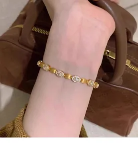 Vue rapprochée d'un élégant bracelet en or et zircons avec maillons ovales sur un poignet