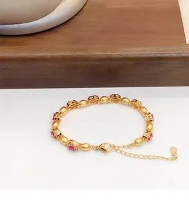 Vue détaillée du bracelet plaqué or orné de pierres de zircon rouges ovales
