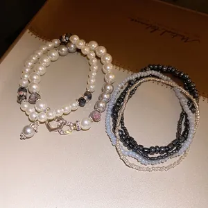 Elegante set di bracciali di perle multistrato in stile boho con charm a cuore.