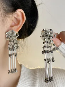 Detail of silver flower tassel earrings with faceted metallic beads and long tubes.