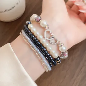 Vista dettagliata di un set di braccialetti bohémien multistrato con perle e cuore