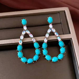 Vintage teardrop earrings with turquoise stones and iridescent crystals in jewelry box