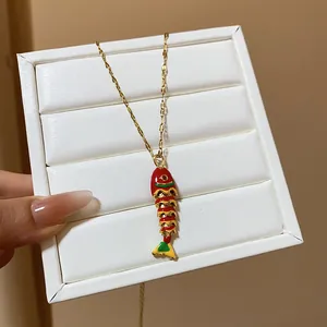 Detailed view of a vibrant enamel fish pendant necklace on a jewelry display.