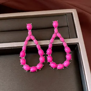 Detailed macro view of vintage-style teardrop earrings featuring vibrant pink stones