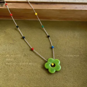 Detailed view of green resin flower pendant necklace featuring vibrant colorful beads