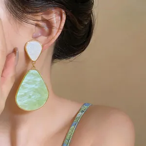 Vista dettagliata degli orecchini pendenti in resina vintage indossati dalla modella