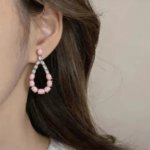 Close-up detail of vintage teardrop earrings featuring elegant pink stones and crystals