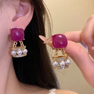 Elegante Vintage-Ohrringe mit lila Harz und weißen Perlen in einer edlen Goldfassung