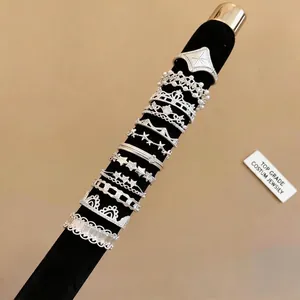 Set of elegant silver lace and star pattern rings on a black velvet display mandrel.