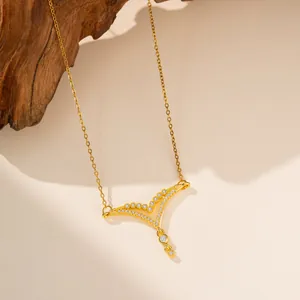 Detalle de colgante en V dorado con circonitas sobre cadena de acero inoxidable