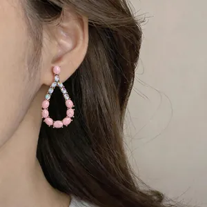 Macro view of vintage teardrop dangle earring with pink stones and iridescent crystals