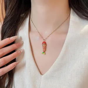 Close-up view of a vibrant colorful fish pendant necklace worn by a model for fashion display