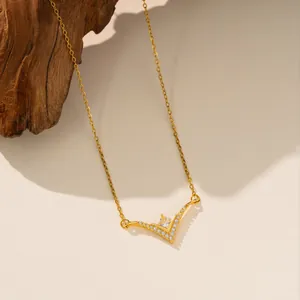 Detalle de un collar de acero de titanio en forma de V con piedras de circón