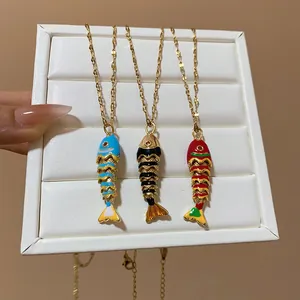 Detailed macro view of three artistic colorful fish bone pendants on gold-plated chains