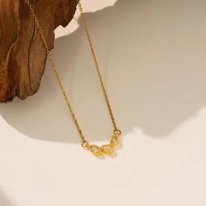 Vista detallada de un collar de acero inoxidable dorado con un colgante de tres zirconitas.