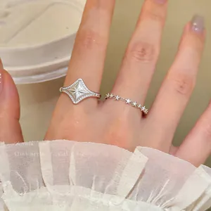 Detail of French style star and diamond-shaped silver rings with elegant lace sleeve.