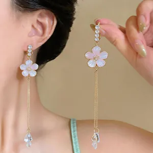 Detailed view of French flower tassel clip earrings featuring iridescent pink petals.