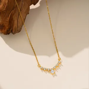 Primer plano de un collar de acero de titanio dorado con colgante de circonita pera